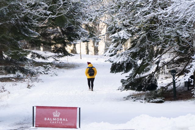 A person walks through the snow on the Balmoral Estate