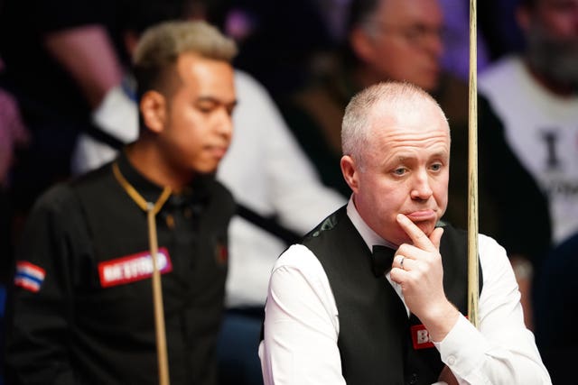 John Higgins (right) in action against Thailand’s Noppon Saengkham at the Crucible