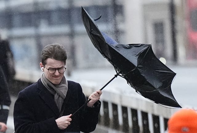 People walk in windy conditions