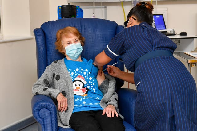 Margaret Keenan, 90, becomes the first person in the world to receive a Covid-19 vaccine as part of a mass vaccination programme on December 8 2020, at University Hospital in Coventry, administered by nurse May Parsons (Jacob King/PA)