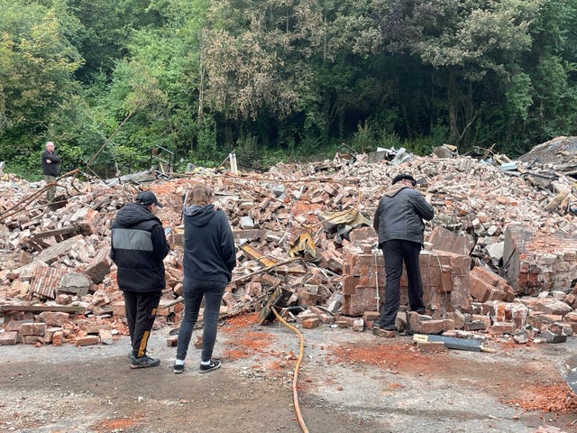 Visitors inspecting the rubble of the site after it was demolished. Hundreds have visited since the fire and the pub's demolition (Matthew Cooper/PA)