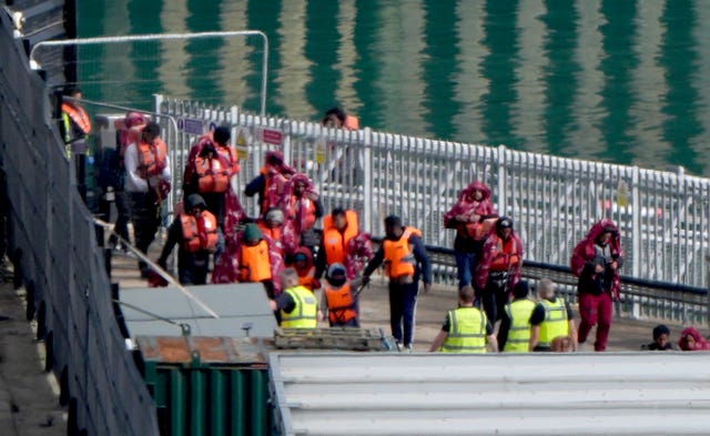 A group of people thought to be migrants being brought in to the Border Force compound in Dover
