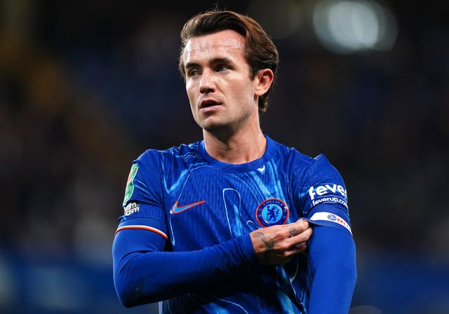 Ben Chilwell adjusts his left sleeve with his right arm during Chelsea's game with Barrow