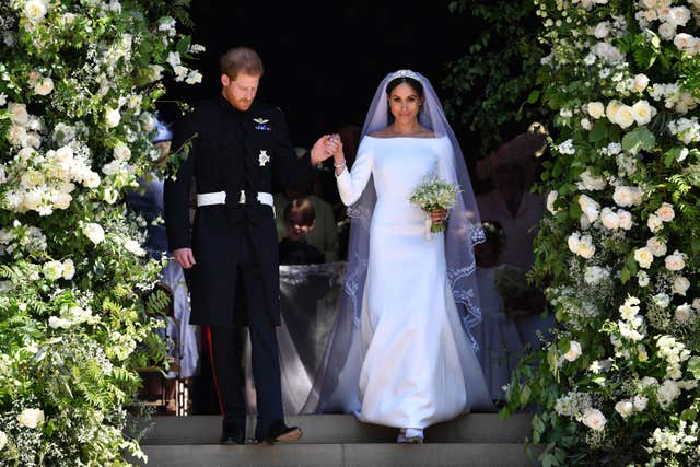 Harry and Meghan surrounded by an archway of flowers on their wedding day 