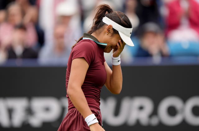 Emma Raducanu holds her hand to her face as she fights back tears