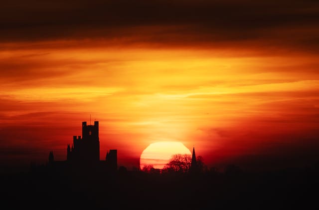 The sun rises behind Ely Cathedral in The Fens.