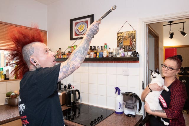 Circus performer Hannibal Hellmurto practises sword swallowing as Anastasia Sawicka, a ‘hair hanger’, looks on at their home in Northampton