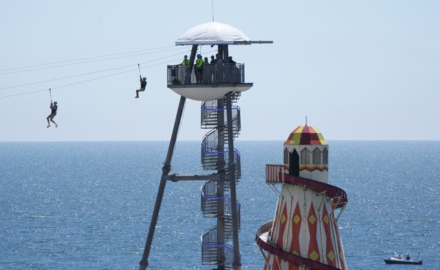 People zip line from Bournemouth pier towards Bournemouth Beach in Dorset, on June 23 2024 