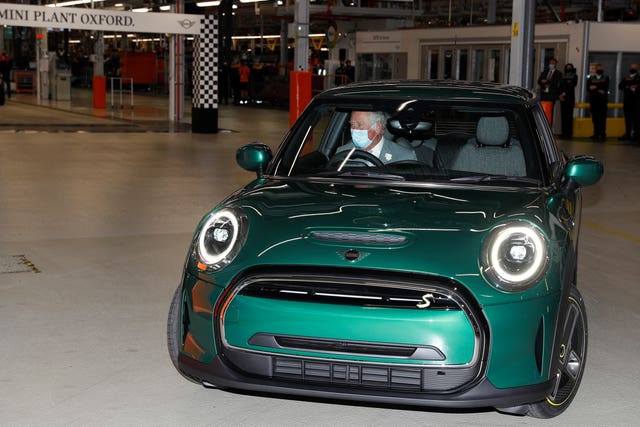 The King, when he was Prince of Wales, drives an electric Mini car during a visit to the Oxford plant