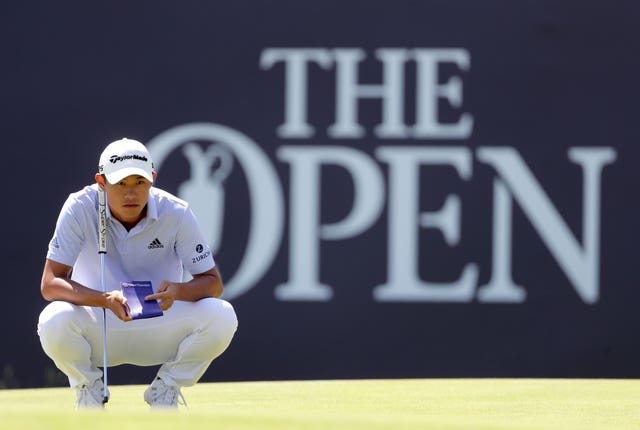 Collin Morikawa lines up a putt on the 18th green