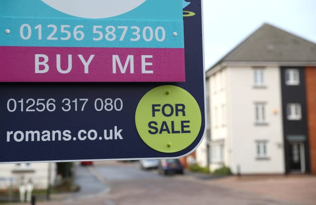 General view of a For Sale and a Buy Me board outside a house for sale in Basingstoke, Hampshire