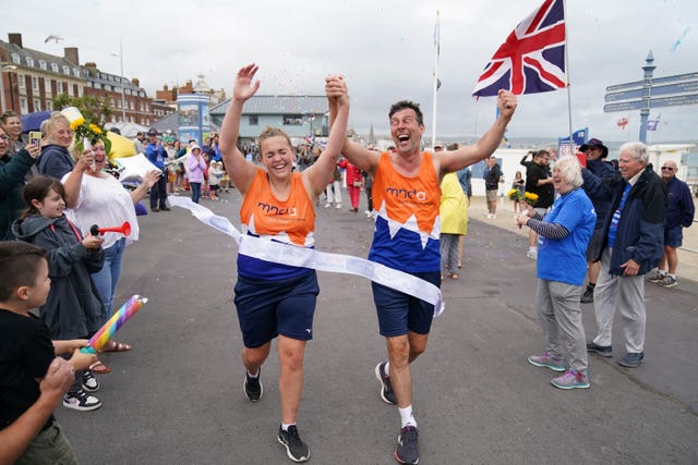 Charlotte Nichols and Stuart Bates finishing their marathon along the seafront on Weymouth Beach in 2021