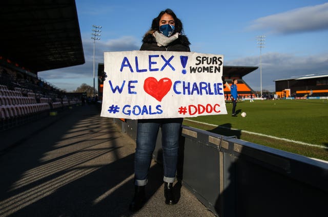 A Tottenham fan holds up a banner in tribute to Alex Morgan