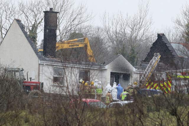 Forensic and fire officers at the house in Derrylin (Brian Lawless/PA)