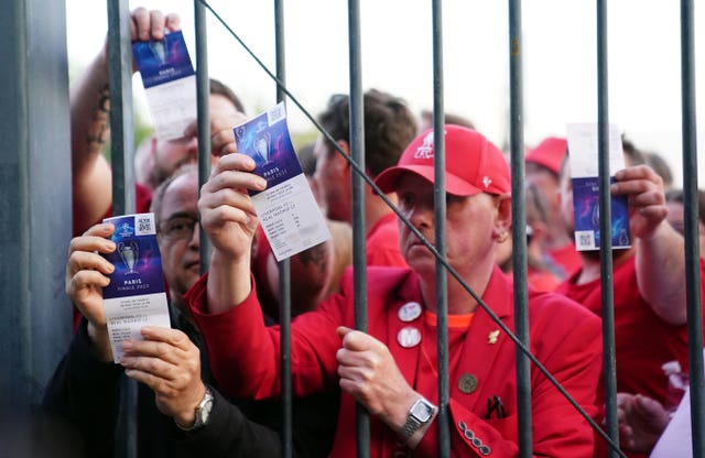 Liverpool fans stuck outside the ground show their match tickets 