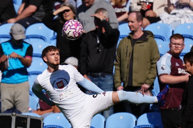 Aston Villa’s Harvey Elliott warms up in front of fans in the stand