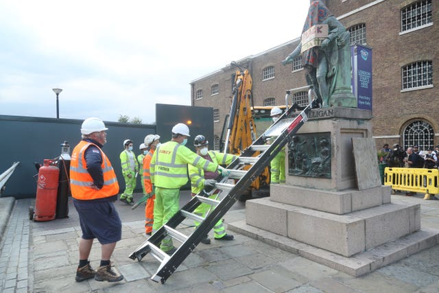 Workers prepare to take down a statue of slave owner Robert Milligan at West India Quay, east London, as Labour councils across England and Wales will begin reviewing monuments and statues in their towns and cities