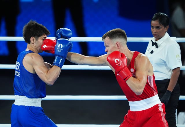 Richardson in red punching Verde in blue with the referee watching on. 