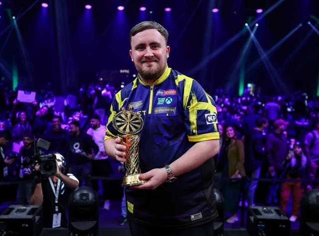 Luke Littler holds the Saudi Arabia Darts Masters trophy 