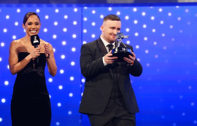 Luke Littler holds up the the Young Sports Personality of the Year trophy