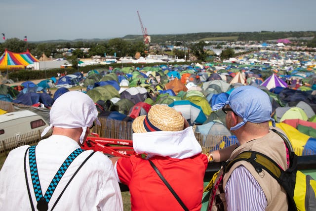 People look over the edge of the pier at the Glastonbury by the Sea attraction on the third day of the Glastonbury Festival at Worthy Farm in Somerset