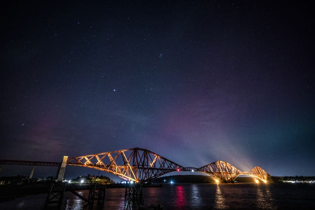 The Northern Lights, also known as the aurora borealis, on display in the skies above the Forth Bridge, North Queensferry in Fife