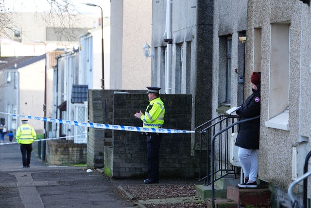 Police officers and police tape outside house