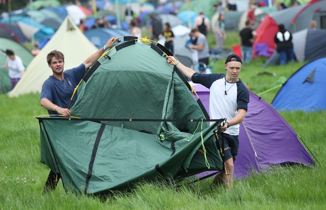 Men carry a tent on the first day of Glastonbury Festival at Worthy Farm, Somerset 