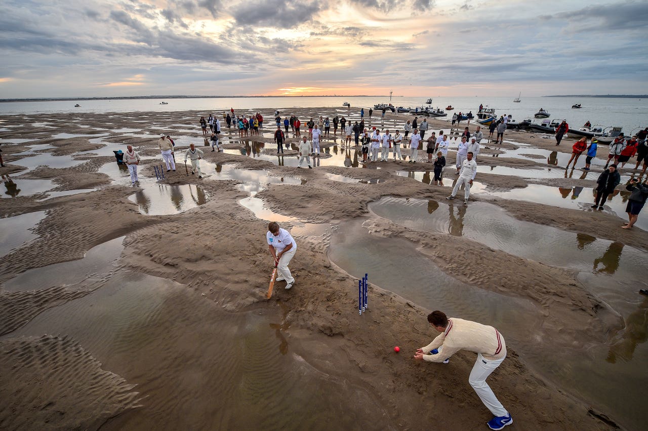 In Pictures: Soggy infield no boundary for sandbank cricket match.