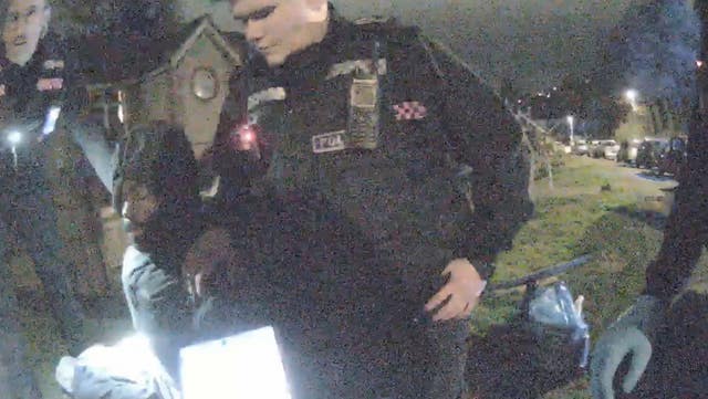 Still from video of Mark Gordon with police officers outside in the dark
