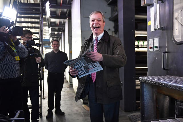 Brexit Party leader Nigel Farage picks up a copy of The Brexiteer during a visit to JPI Printers in Dinnington, South Yorkshire 