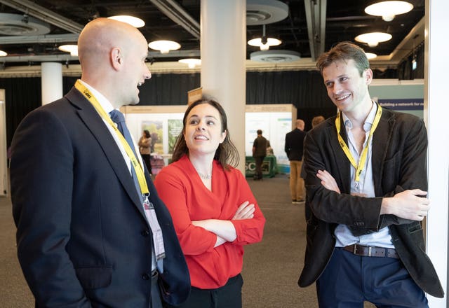 Deputy First Minister Kate Forbes (centre) and Stephen Flynn (left) visit the exhibitors' hall during the SNP conference 