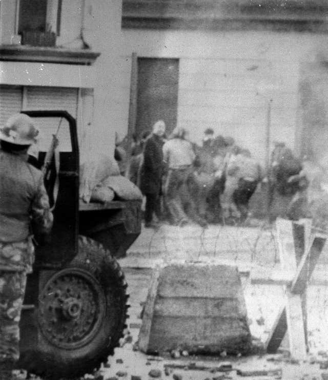 Soldiers taking cover behind their sandbagged armoured cars while dispersing rioters with CS gas during a protest in Londonderry which became known as Bloody Sunday