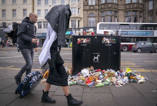 people walking past overflowing bins in Edinburgh city centre
