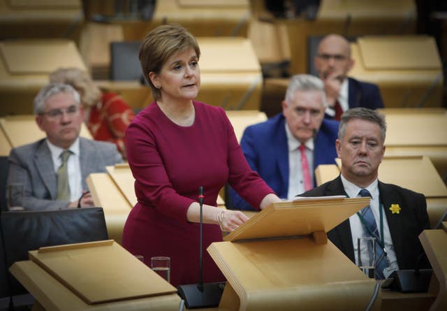 Nicola Sturgeon standing while speaking in Holyrood