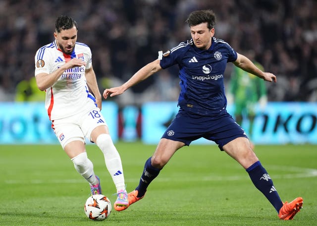 Lyon’s Rayan Cherki challenges for the ball with Manchester United’s Harry Maguire 