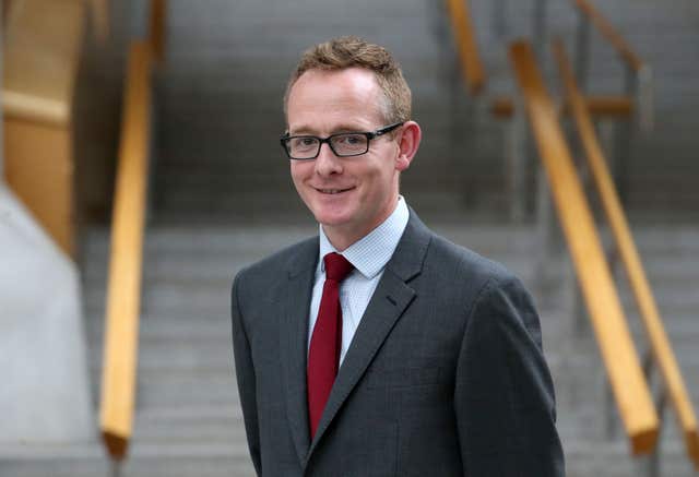 John Lamont smiles at the camera in a photocall at Holyrood