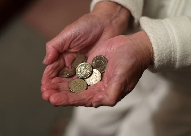 File photo of an elderly woman holding pound coins in her hands