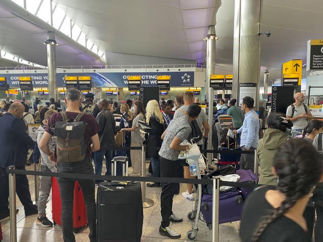 Passengers queue to check-in at terminal 2 at Heathrow Airport