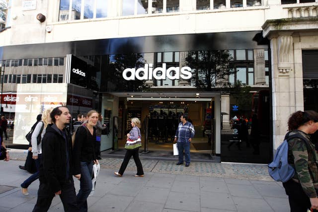 People walking in front of an Adidas store