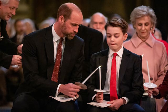 The Prince of Wales and Prince George light candles during the service