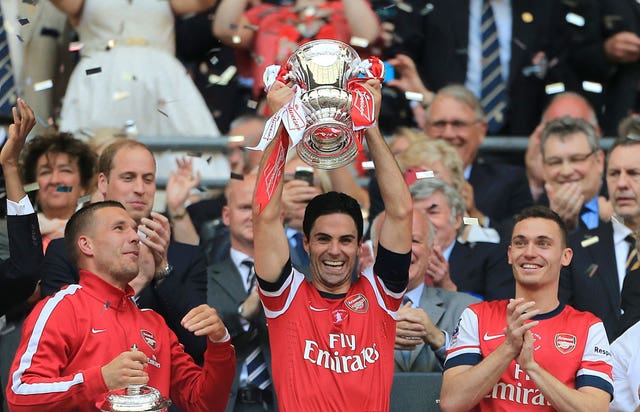 Mikel Arteta, centre, lifts the FA Cup in 2014