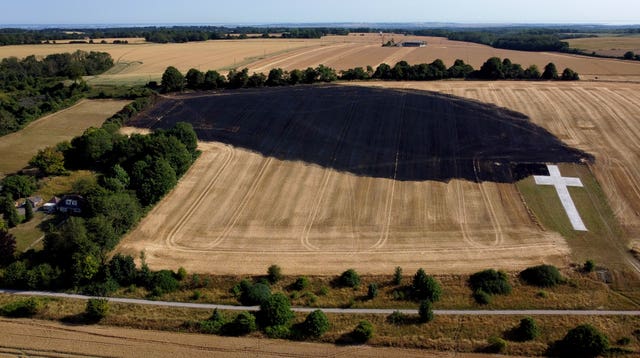 A view of the aftermath of a field fire which threatened the Lenham Cross war memorial near the village of Lenham in Kent 