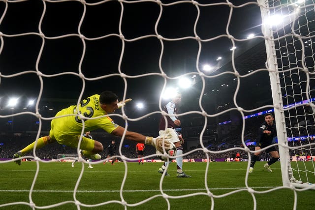 Aston Villa goalkeeper Emiliano Martinez dives low to his right to claw the ball off the line