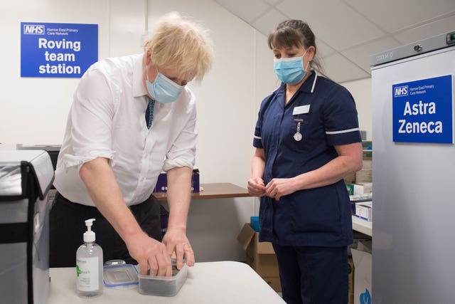 Prime Minister Boris Johnson sees how a dose of the Oxford/AstraZeneca Covid 19 vaccine is prepared, with nurse, Tracey Wilkinson (Stefan Rousseau/PA)