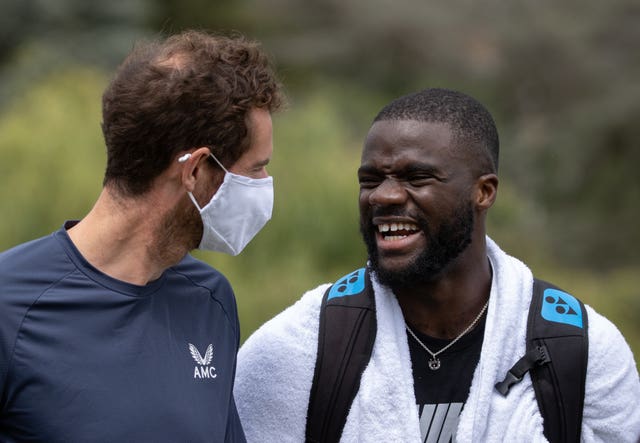 Andy Murray (left) shares a joke with Frances Tiafoe at the practice courts on Tuesday