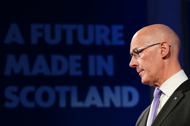 John Swinney in front of a sign reading 'A future made in Scotland'