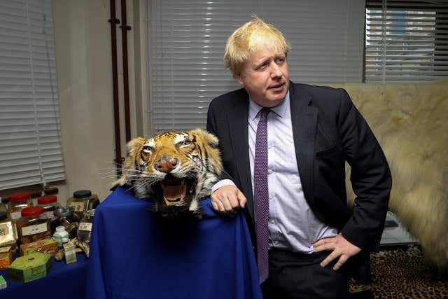 Boris Johnson next to a seized tiger skin rug during his visit to a Metropolitan Police Wildlife Crime Unit facility in south London (Simon Dawsoon/PA)