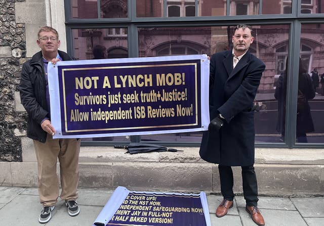 Abuse survivor Craig Freedman standing outside the Church of England’s General Synod holding a sign