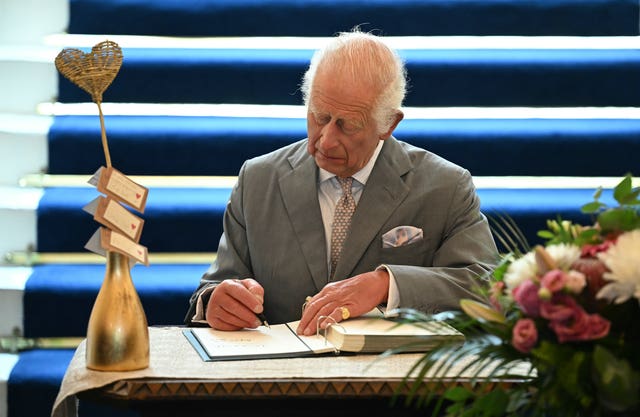 The King signing a book of condolence in the town hall